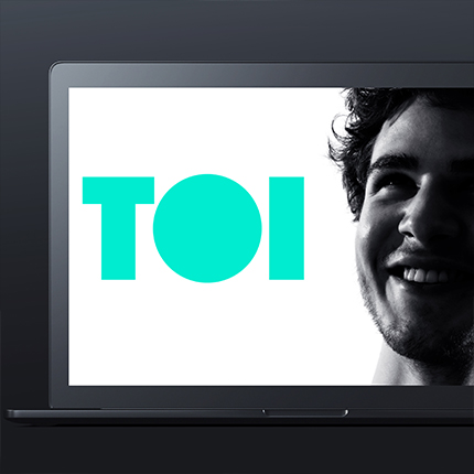 TOI logo with man smiling on the right hand side of logo